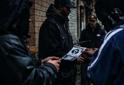 A flyer being handed over outside at night