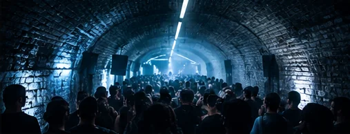 A crowd packed into a brick railway arch under a single beam
