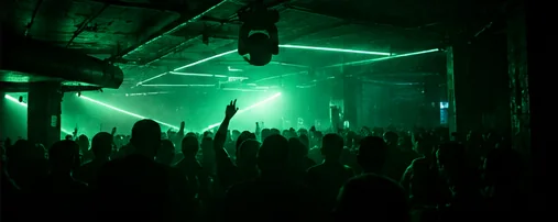 Green lasers cutting across a low concrete ceiling